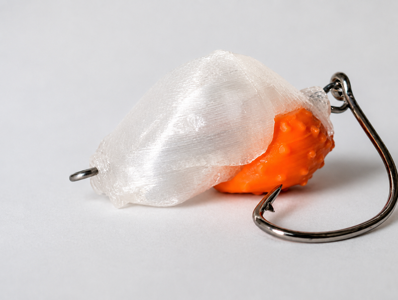 SandSpawn Pompano Sushi artificial sand flea lure in pearl and orange with hook on a white background.