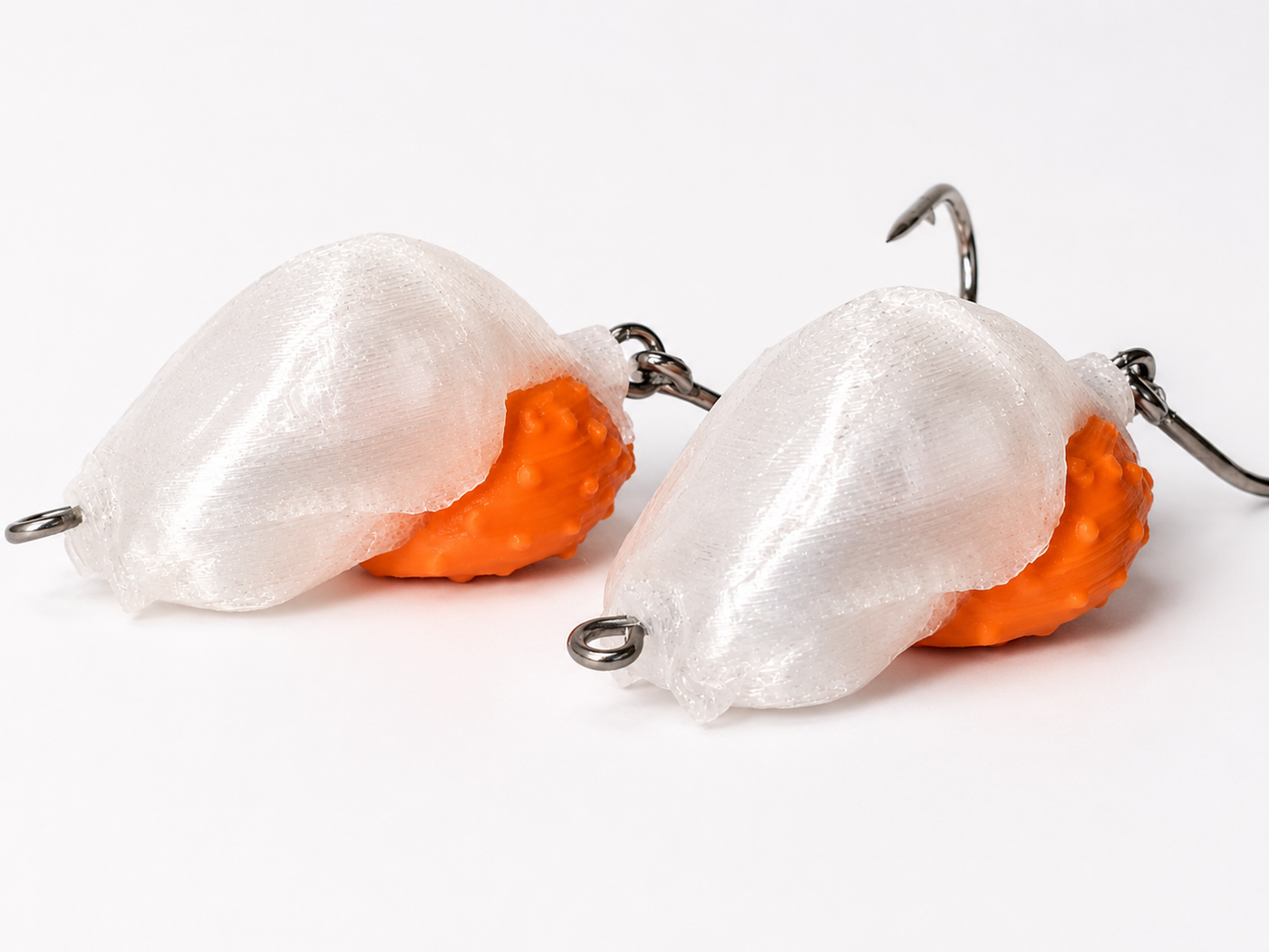 Two SandSpawn Pompano Sushi artificial sand flea lures rigged and ready to fish in pearl and orange with hooks on a white background.
