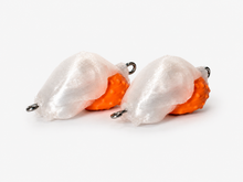 Two SandSpawn Pompano Sushi artificial sand flea lures in pearl and orange without hooks on a white background.