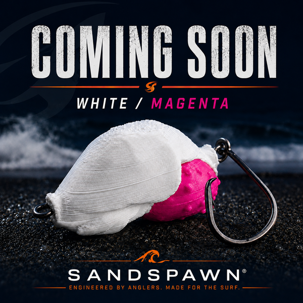 White and magenta SandSpawn fishing lure with circle hook on wet beach sand, coming soon colorway for surf fishing.